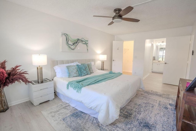 9785 Pineapple Tree Dr Unit 103, Boynton Beach, FL 33436 - bedroom featuring wood finished floors, a textured ceiling, ensuite bath, and ceiling fan