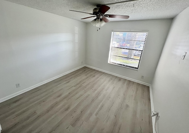 empty room featuring baseboards, ceiling fan, a textured ceiling, and wood finished floors
