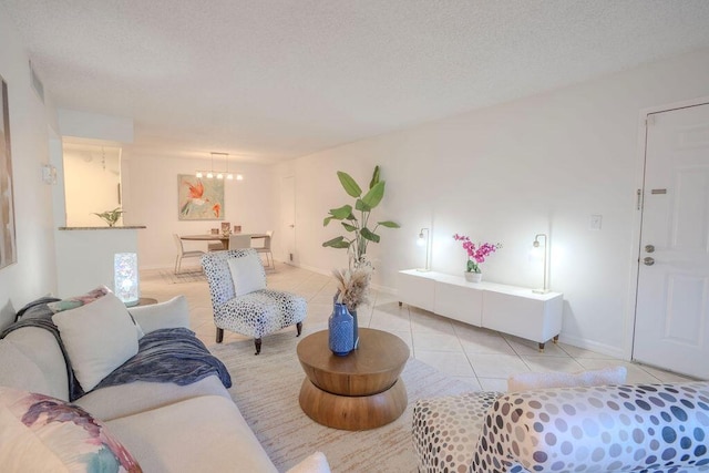 9785 Pineapple Tree Dr Unit 103, Boynton Beach, FL 33436 - living area with light tile patterned floors, a chandelier, and a textured ceiling
