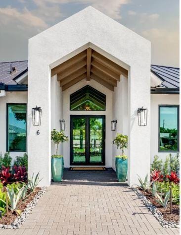 doorway to property with a standing seam roof, metal roof, french doors, and stucco siding