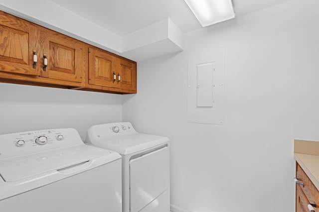 clothes washing area with cabinet space, electric panel, and independent washer and dryer