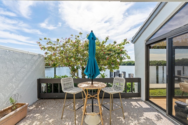 view of patio with a water view and a balcony