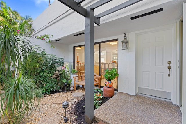 entrance to property featuring stucco siding