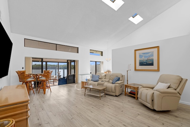 living area featuring high vaulted ceiling, a skylight, and light wood finished floors