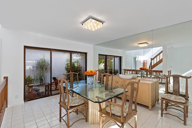 dining area with light tile patterned flooring and stairs