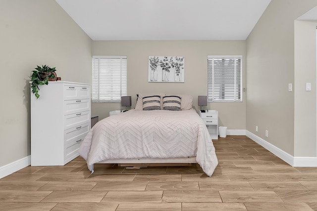 bedroom with wood finish floors, vaulted ceiling, and baseboards