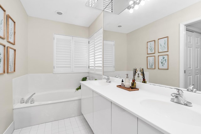 bathroom featuring a bath, double vanity, a sink, and tile patterned floors