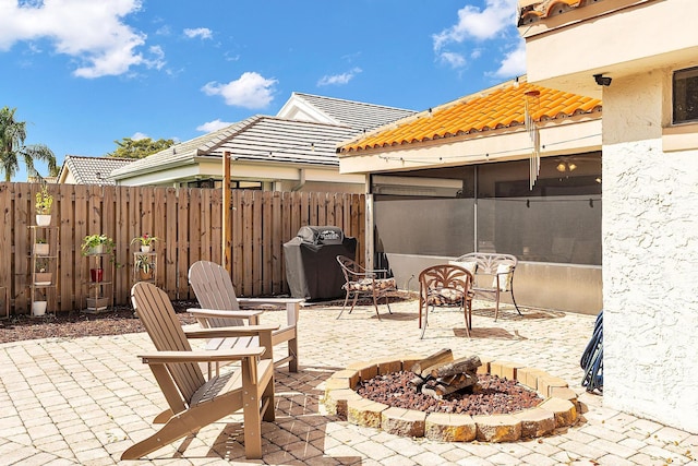 view of patio featuring fence, a fire pit, and area for grilling