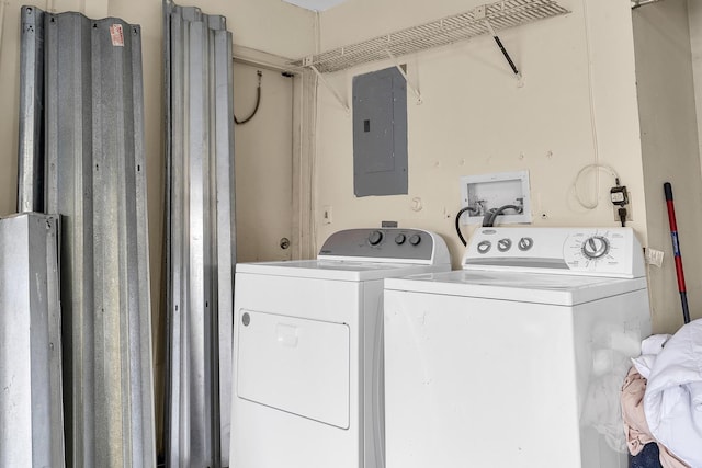 laundry room with laundry area, washing machine and dryer, and electric panel