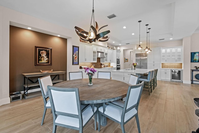 dining area featuring light wood-type flooring, beverage cooler, visible vents, and recessed lighting