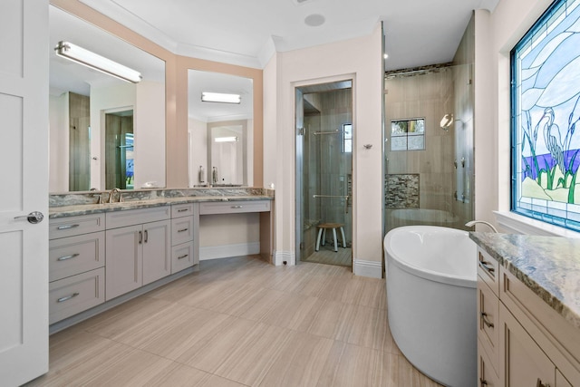 bathroom with vanity, baseboards, ornamental molding, a soaking tub, and a stall shower