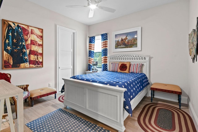 bedroom with ceiling fan, baseboards, and wood finished floors