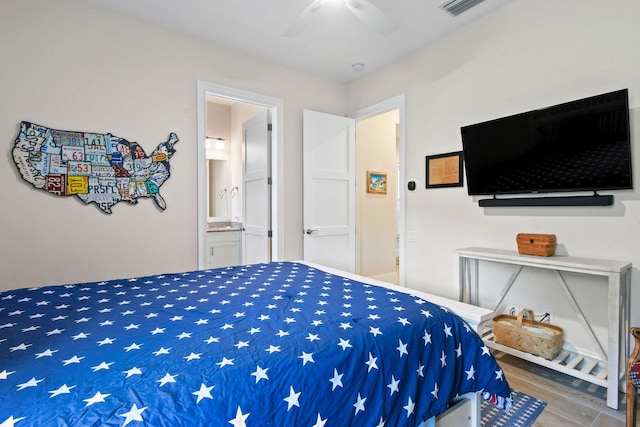 bedroom featuring ensuite bath, ceiling fan, visible vents, and wood finished floors