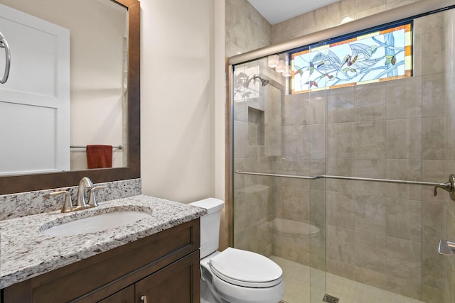 full bath with vanity, a shower stall, and toilet