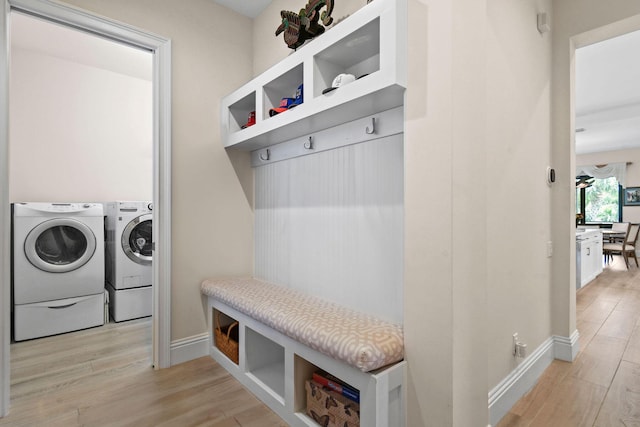 mudroom with baseboards, separate washer and dryer, and light wood-style floors