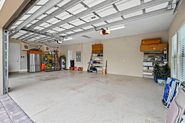 garage with a garage door opener, freestanding refrigerator, and water heater