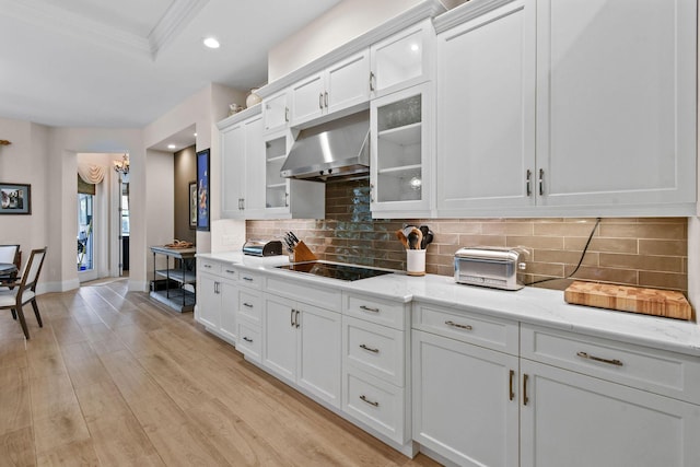 kitchen featuring light wood-type flooring, range hood, white cabinets, and glass insert cabinets