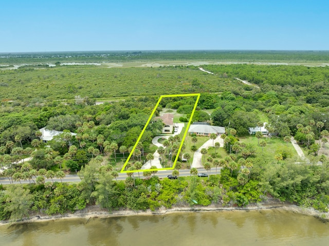 drone / aerial view featuring a water view and a view of trees