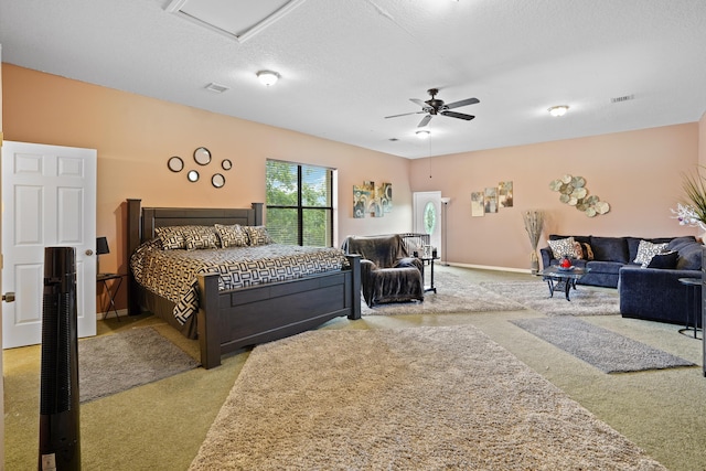 carpeted bedroom featuring a ceiling fan, visible vents, a textured ceiling, and baseboards