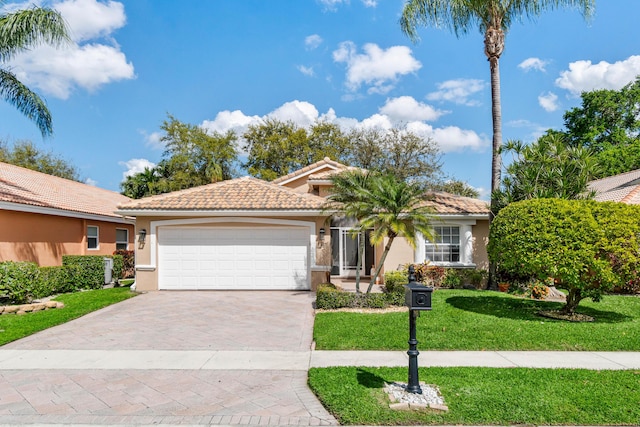 view of front of house with a front lawn, decorative driveway, an attached garage, and a tile roof