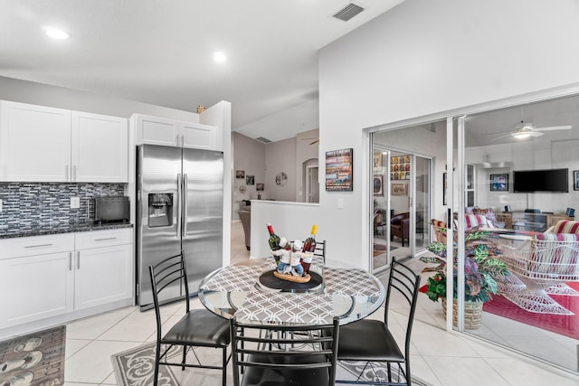 kitchen featuring ceiling fan, light tile patterned flooring, visible vents, tasteful backsplash, and stainless steel fridge