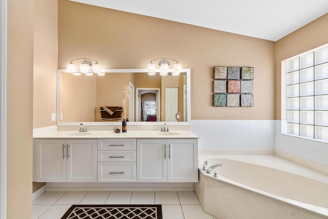 full bath with double vanity, a garden tub, a sink, and tile patterned floors