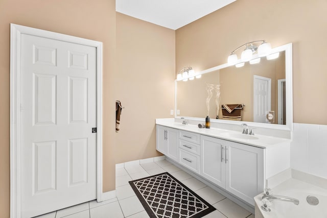 full bath featuring double vanity, a garden tub, tile patterned flooring, and a sink