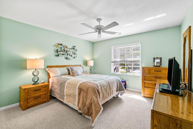 bedroom with a ceiling fan, carpet, a textured ceiling, and baseboards