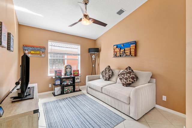 living area featuring light tile patterned floors, lofted ceiling, visible vents, a ceiling fan, and a textured ceiling