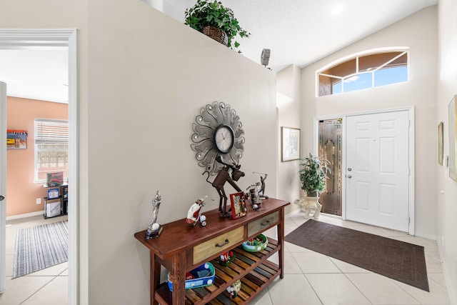 foyer entrance with plenty of natural light, baseboards, and light tile patterned floors