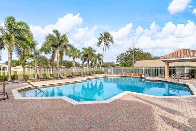 pool with a patio area and fence