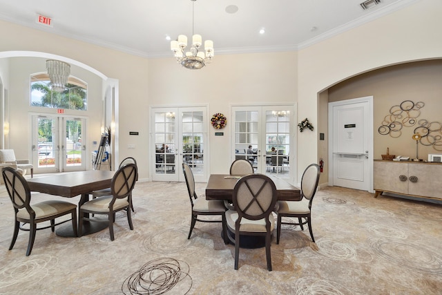 dining room with a towering ceiling, baseboards, french doors, an inviting chandelier, and crown molding