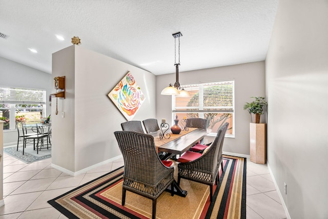 dining area with light tile patterned floors, a textured ceiling, a wealth of natural light, and baseboards