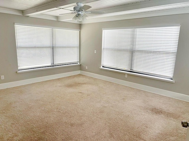 empty room featuring ceiling fan, baseboards, beam ceiling, and carpet flooring