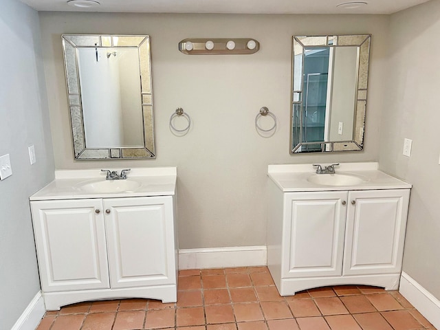 bathroom featuring two vanities, a sink, tile patterned flooring, and baseboards