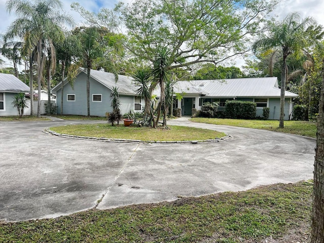 ranch-style house featuring a front yard and concrete driveway