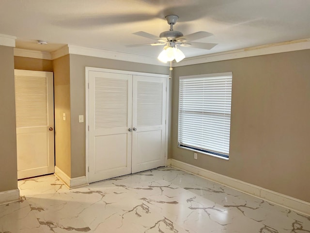 unfurnished bedroom with baseboards, marble finish floor, a closet, and crown molding