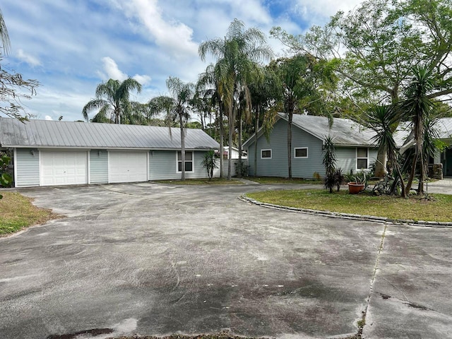 single story home with driveway and an attached garage