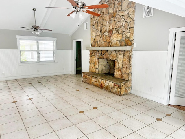 unfurnished living room with lofted ceiling with beams, a wainscoted wall, a fireplace, and visible vents