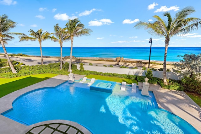 pool with a water view, a patio, and a beach view