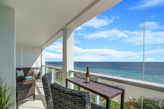 balcony with a water view and a view of the beach