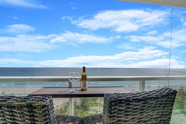 balcony featuring a water view and a beach view