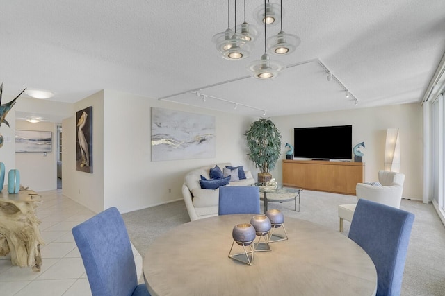 dining area with light tile patterned flooring, a textured ceiling, and track lighting