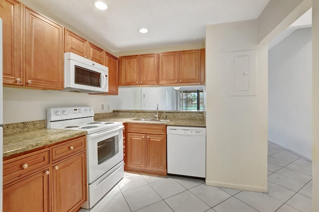 kitchen featuring light tile patterned floors, light stone counters, white appliances, a sink, and electric panel