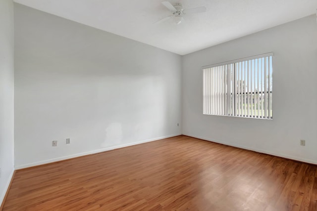 spare room with baseboards, a ceiling fan, and wood finished floors