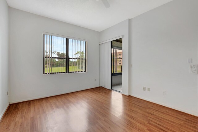 spare room with ceiling fan, wood finished floors, and baseboards