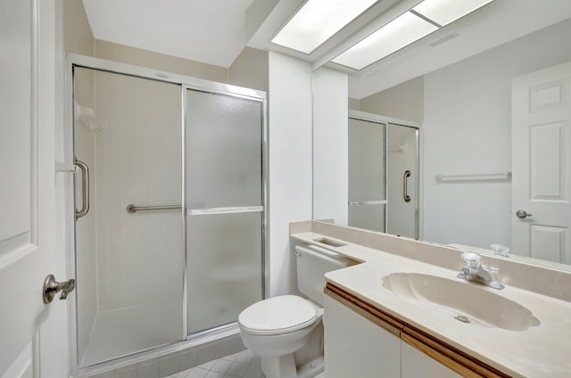 bathroom with tile patterned floors, a shower stall, toilet, and vanity