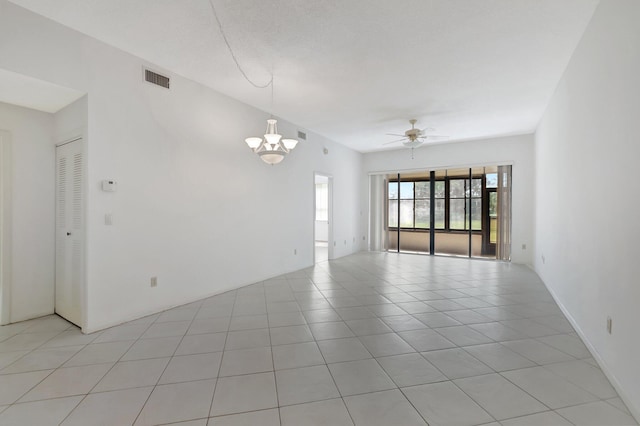 unfurnished room with light tile patterned floors, ceiling fan with notable chandelier, and visible vents