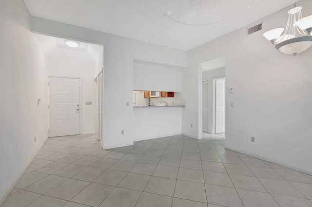 spare room featuring light tile patterned flooring, a notable chandelier, and visible vents