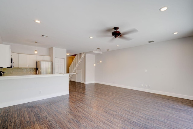 unfurnished living room featuring visible vents, dark wood finished floors, stairway, and baseboards